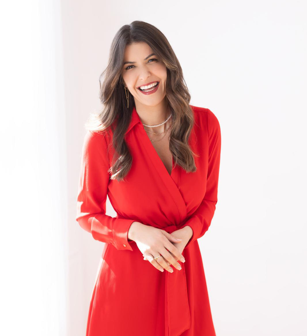Cintia Stoehr in a red dress, smiling.